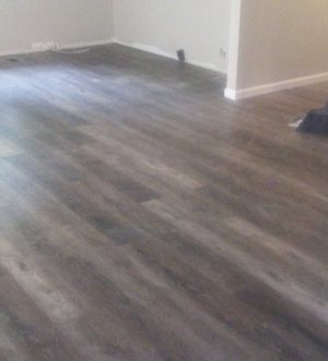 A room featuring wooden floors and a white staircase, creating a bright and inviting atmosphere.