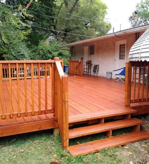 A wooden deck featuring steps and a ladder, designed for access and outdoor activities.