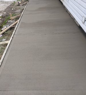Concrete patio construction underway in a Chicago cityscape, showcasing workers and materials on-site.
