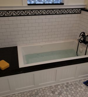 A clean bathroom featuring a white tub and a modern sink against neutral-colored walls.
